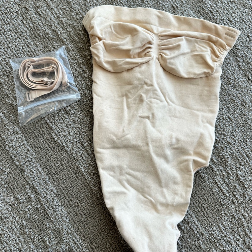 SKIMS seamless sculpt strapless thong bodysuit in color sand and size small